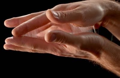 Slow motion close up locked down shot of a person freeing palms stuck together by glue. Shot in Slovenia.